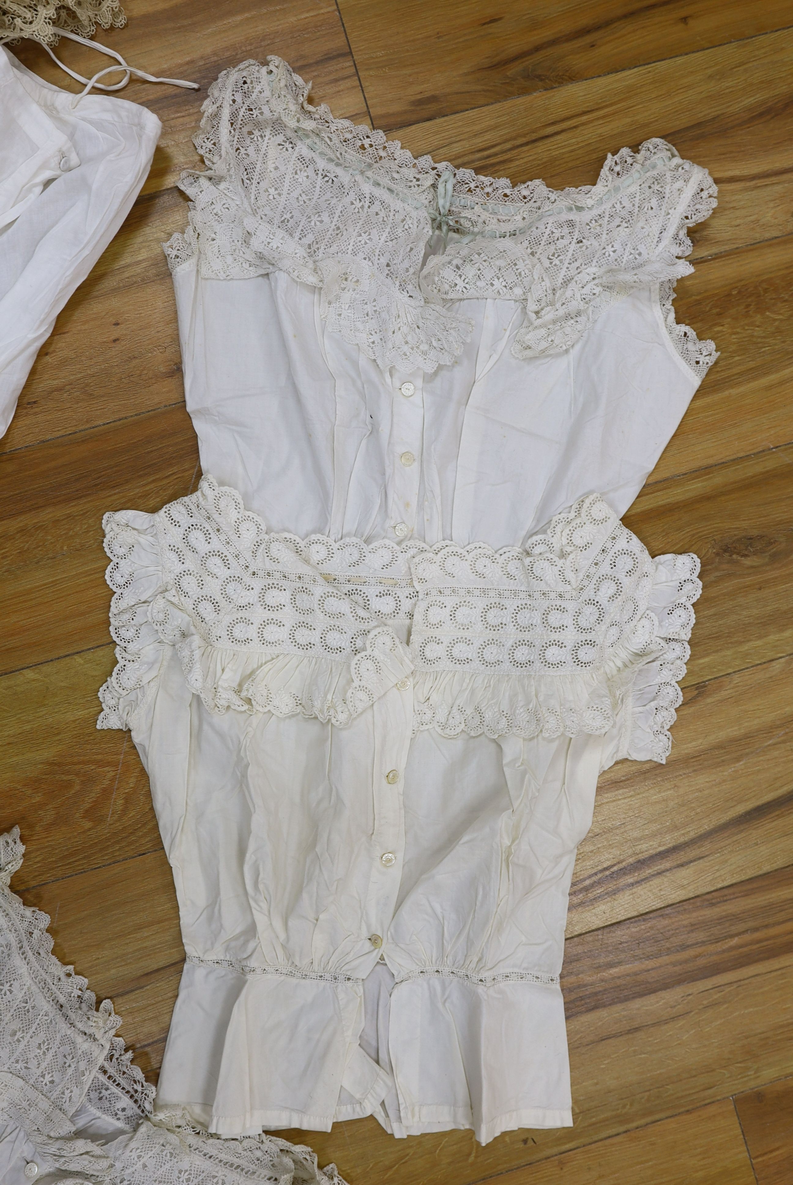 Five Victorian and Edwardian lace inserted camisole tops, a cream chemical lace jacket and a whitework and lace petticoat